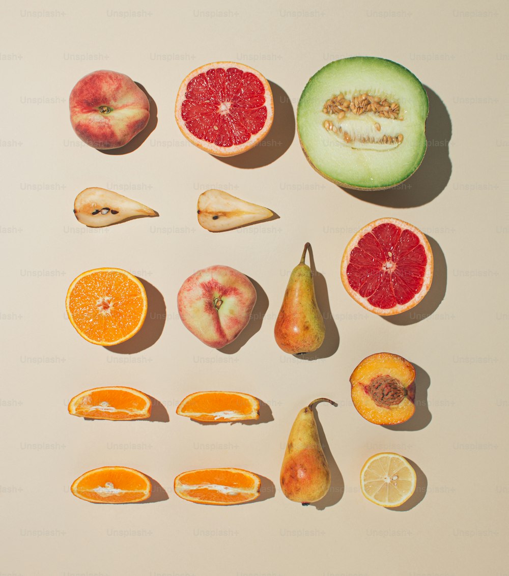 Frutta fresca ordinatamente disposta su sfondo color sabbia. Posa piatta minimale.