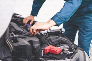 Mécanicien professionnel assurant un service de réparation et d’entretien automobile dans un garage automobile. Concept d’entreprise de service automobile.