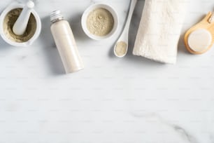 Polvo de ubtan, ingredientes de mascarillas caseras, cepillo de limpieza, torre, sobre mesa de mármol. SPA cosmética natural para el cuidado de la piel del rostro.
