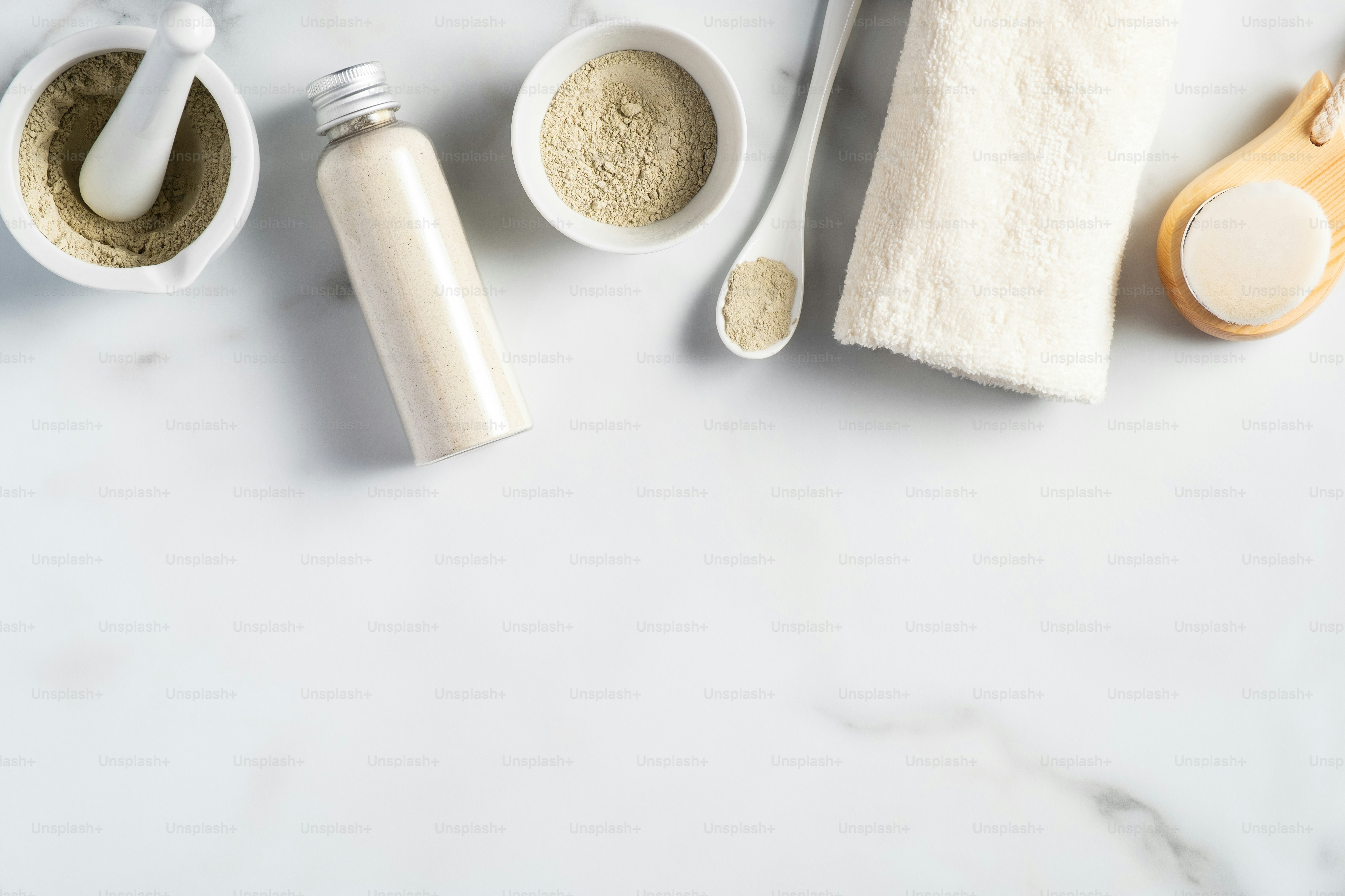 Ubtan powder, homemade face mask ingredients, cleaning brush, tower, on marble table. SPA natural cosmetics for facial skin care.