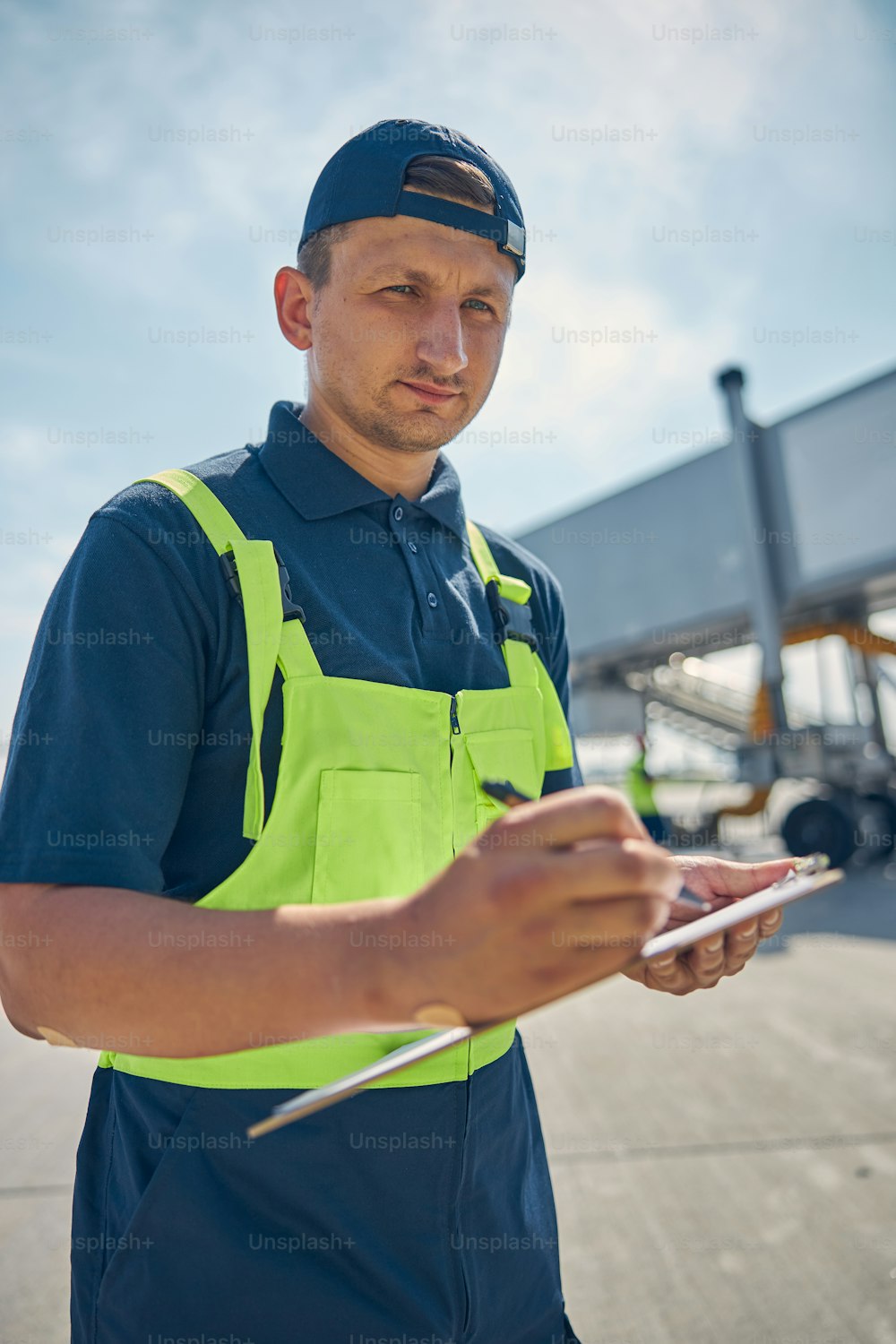 Aviation mechanic with a clipboard and a pen in his hands looking at the camera