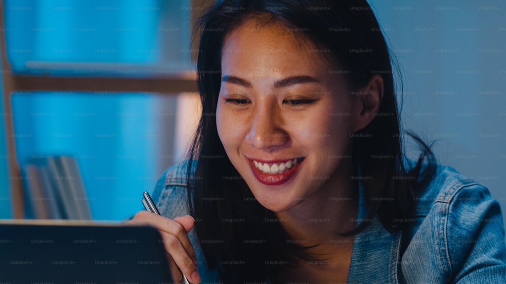 아시아 프리랜서 똑똑한 비즈니스 여성들은 밤에 집 거실에서 노트북으로 작업하면서 인스턴트라면을 먹고 있다. 책상에 앉아 초과 근무를 하는 행복한 아시아 소녀, 휴식 시간을 즐긴다.