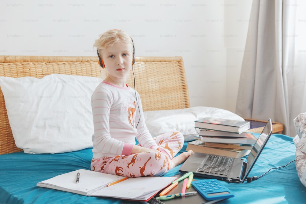 Kaukasisches Mädchen lernt online auf Laptop Internet. Virtuelle Klassenschule per Videoanruf während der Selbstisolationsquarantäne zu Hause. Fernunterricht. Neue Normalität und Homeschooling.