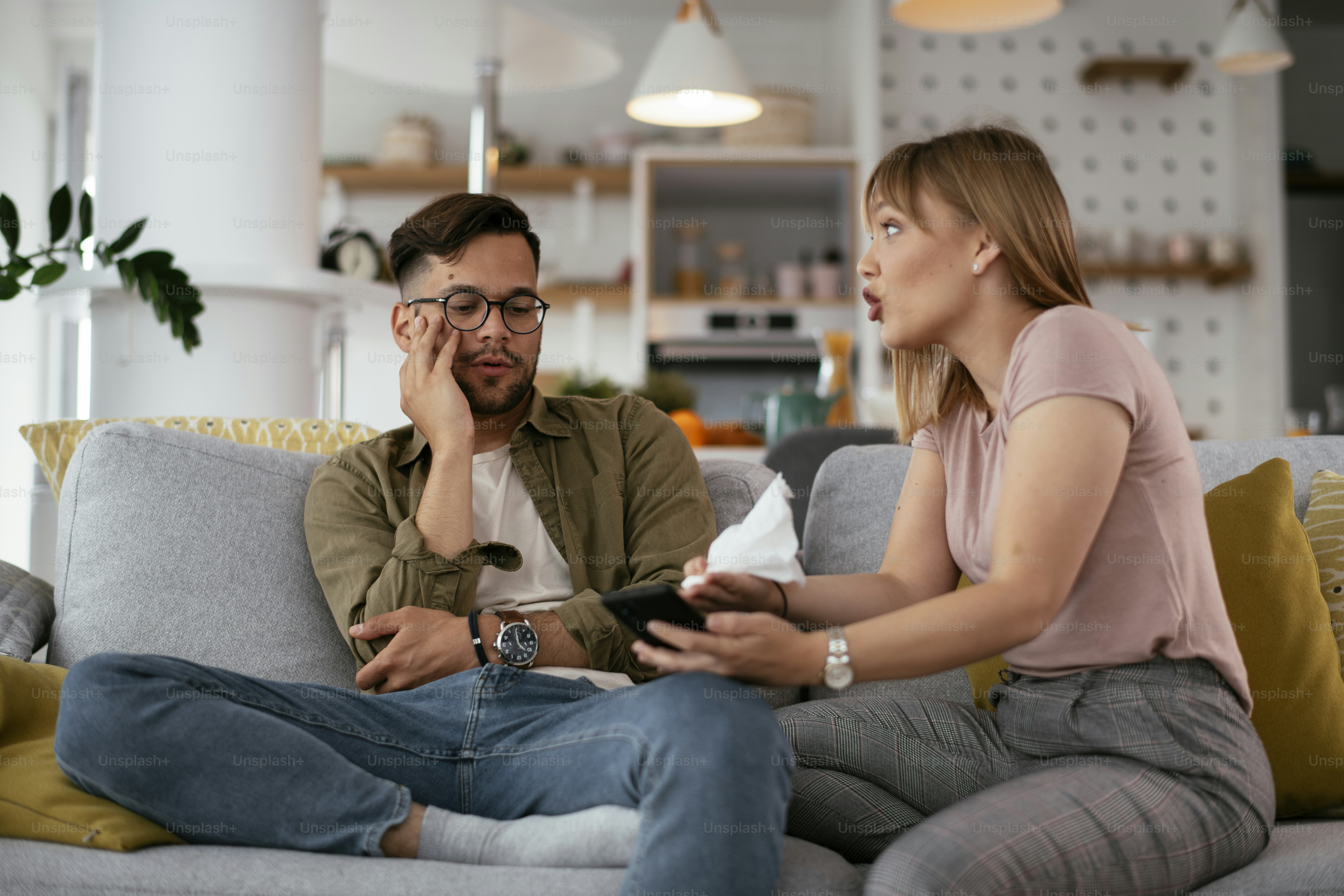 Pacar dan pacar berdebat di sofa. Wanita yang marah berteriak pada pacarnya.