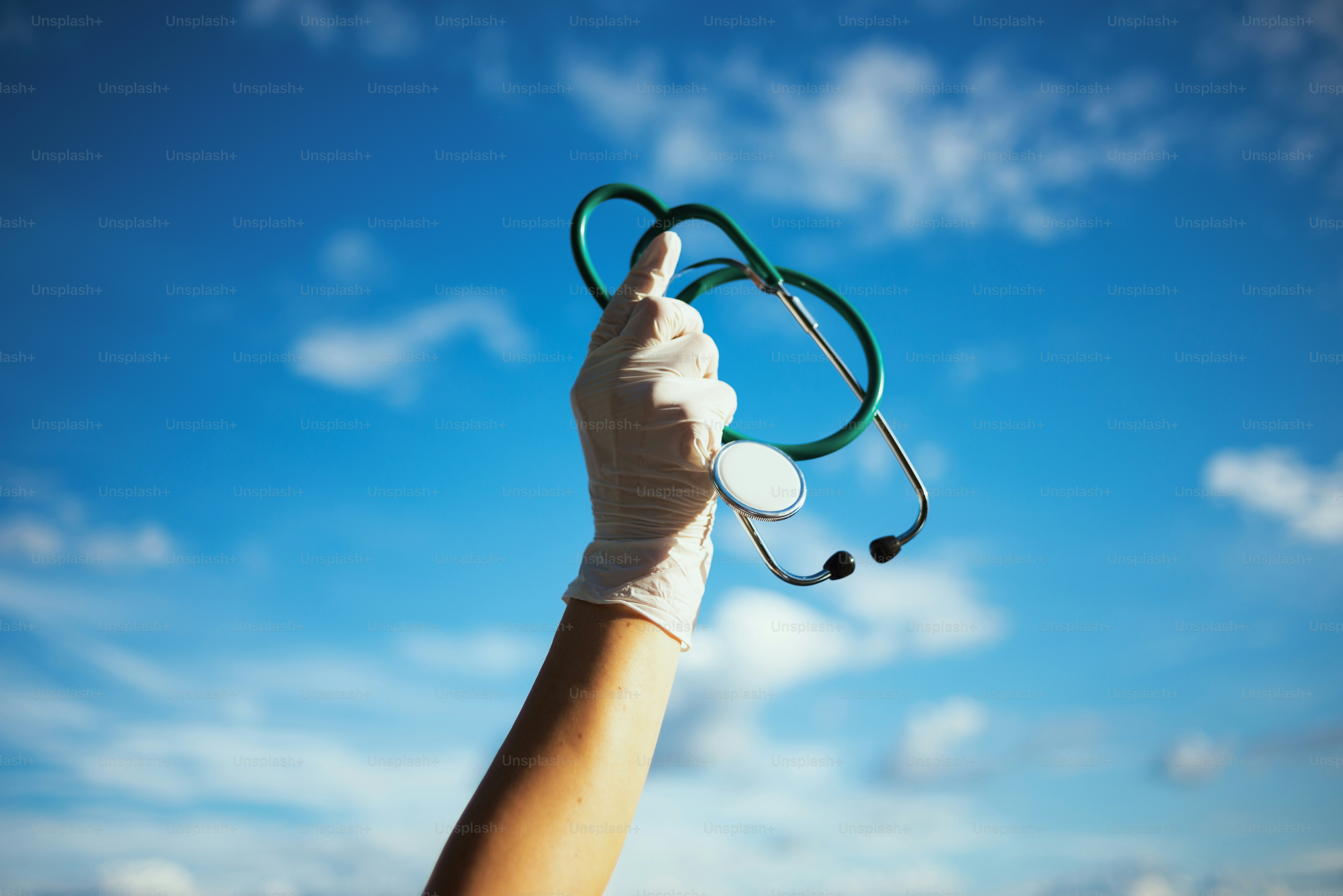 coronavirus pandemic. Closeup on medical practitioner woman with stethoscope and rubber gloves outside against sky.