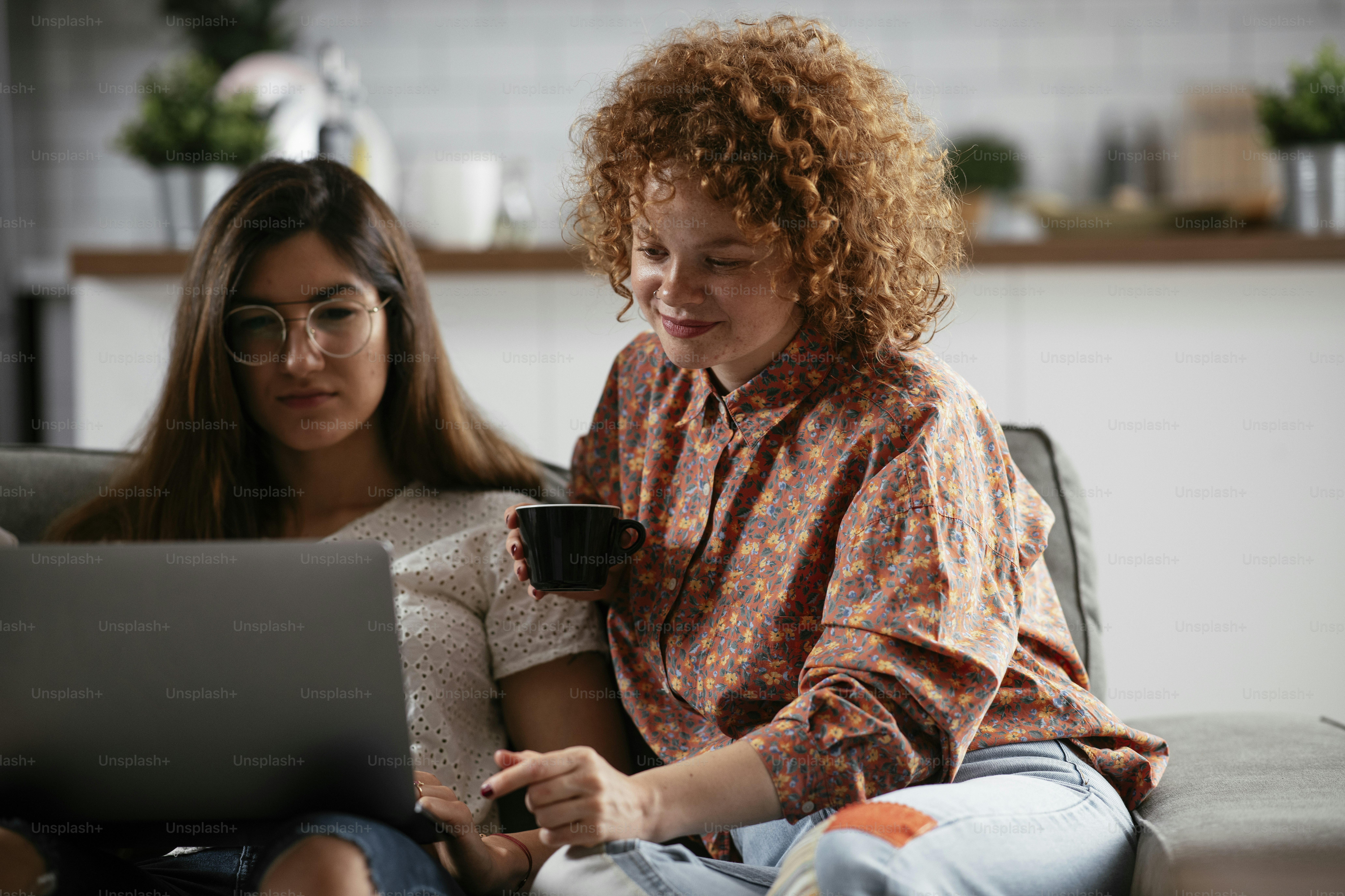 Glückliche Geschäftsfrauen, die im Büro reden und lachen. Schöne Frauen in der Kaffeepause.