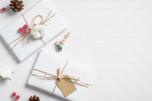 Umweltfreundliche Weihnachtsdekoration und Geschenkboxen auf weißem Hintergrund. Flache Lage, Draufsicht. Minimalistischer Stil.