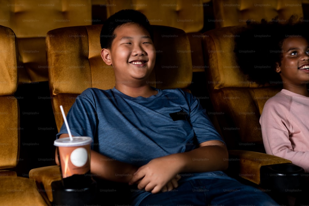 映画館で映画を観て楽しんでいる3人の子供