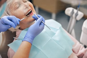 Close up portrait of elderly beautiful female having dental check up in dental professional office