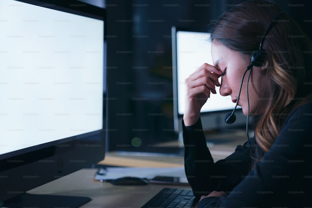 Thai asian women call center business people get headache and migraine from working late night shift for helping assistance customer in workplace at night time