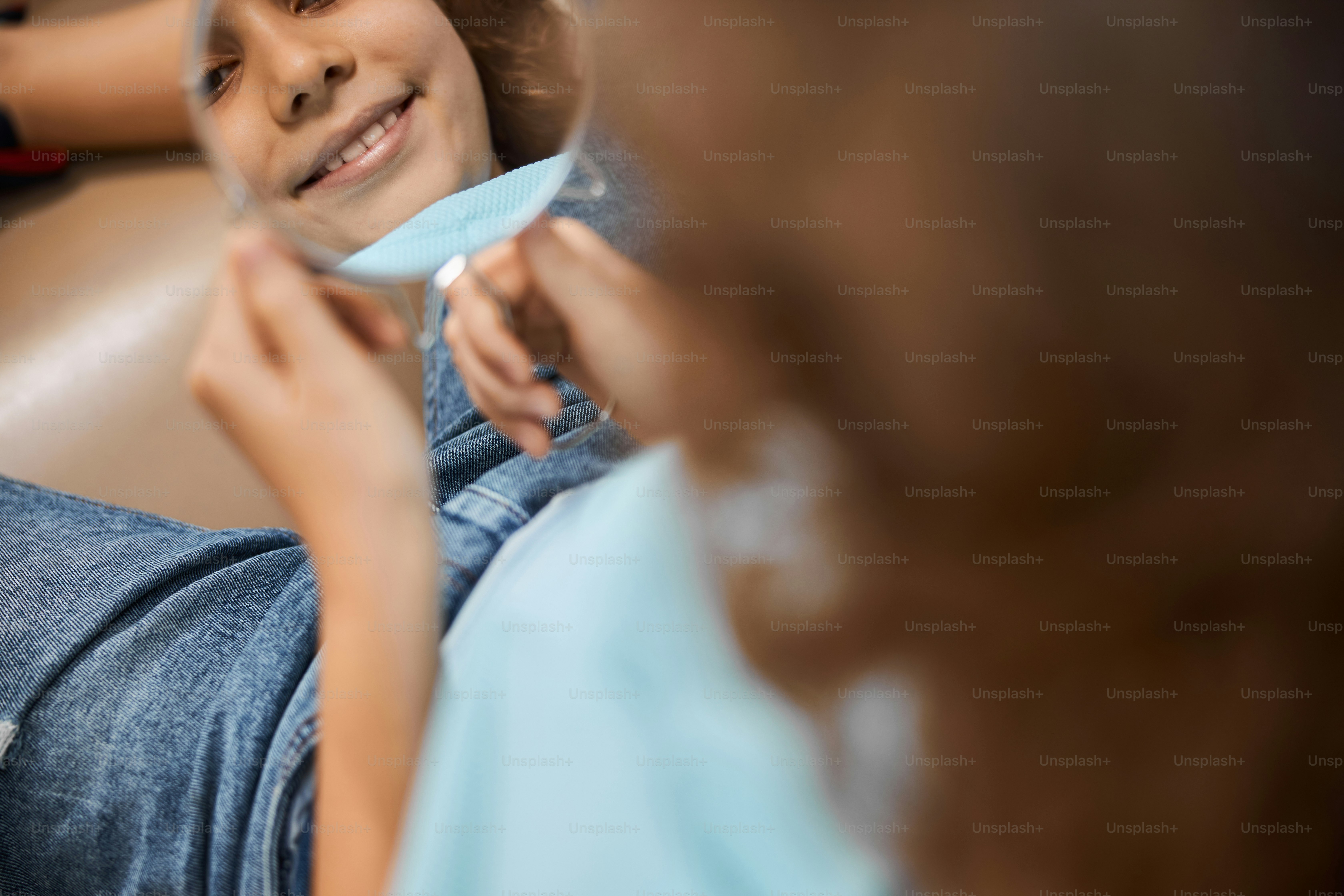 Primer plano de un niño feliz mirando su reflejo en el espejo en una clínica dental