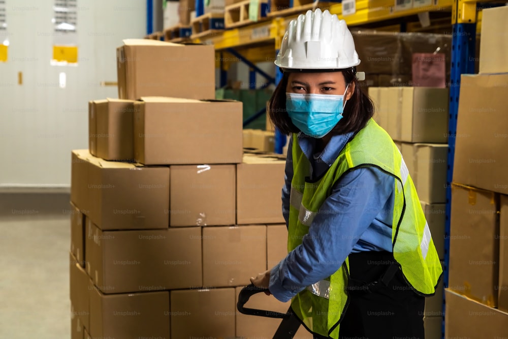작업 재개 기간 동안 Covid-19 코로나바이러스 확산을 방지하기 위해 안면 마스크를 착용하고 작업하는 공장 산업 노동자.