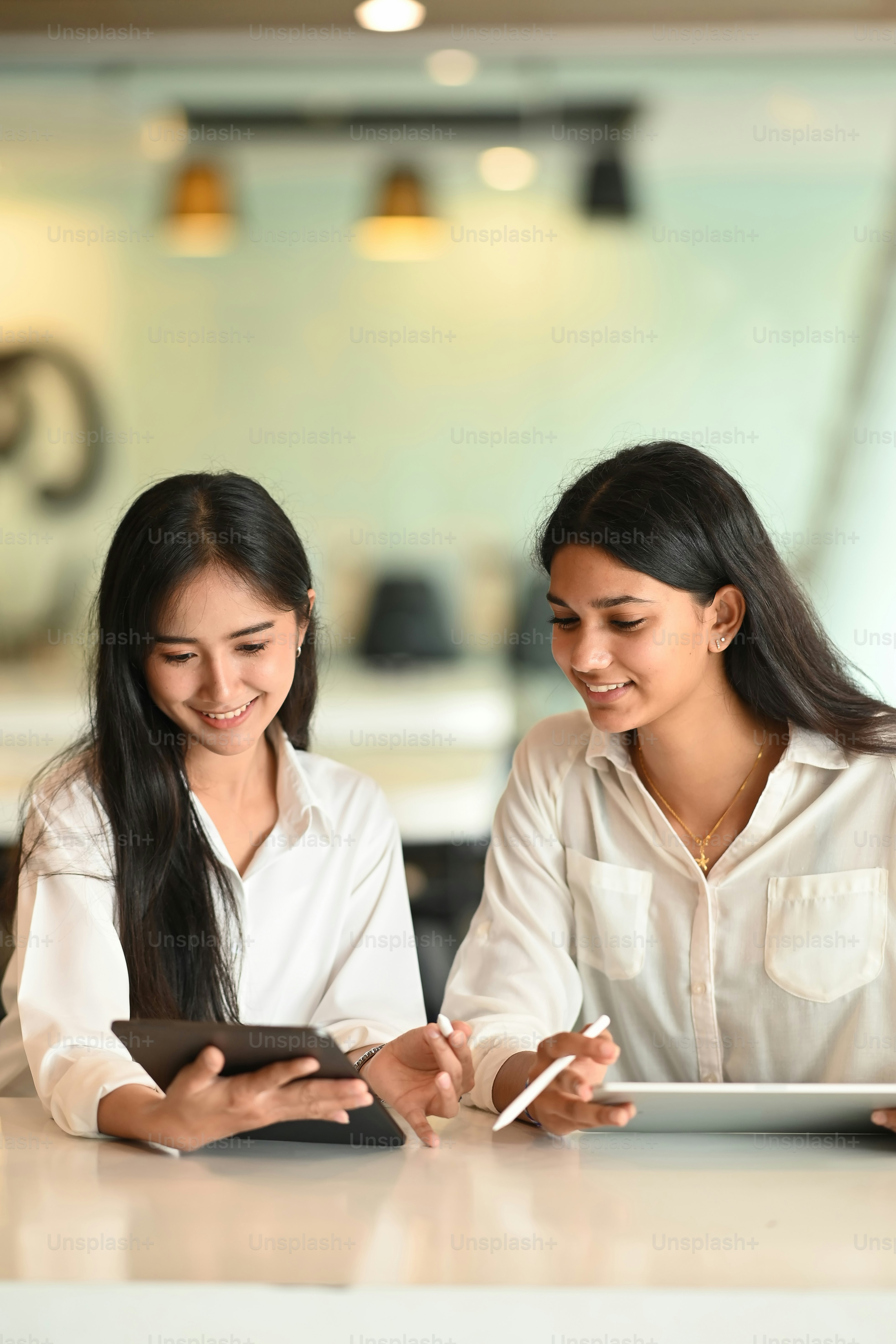 Dos colegas mujer creativa trabajando con tableta digital.