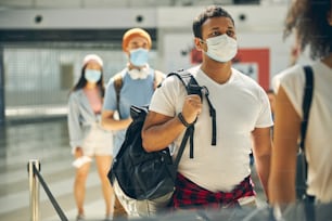 Indian handsome male in white shirt holding backpack on shoulder while waiting for a traveling by plane to another country