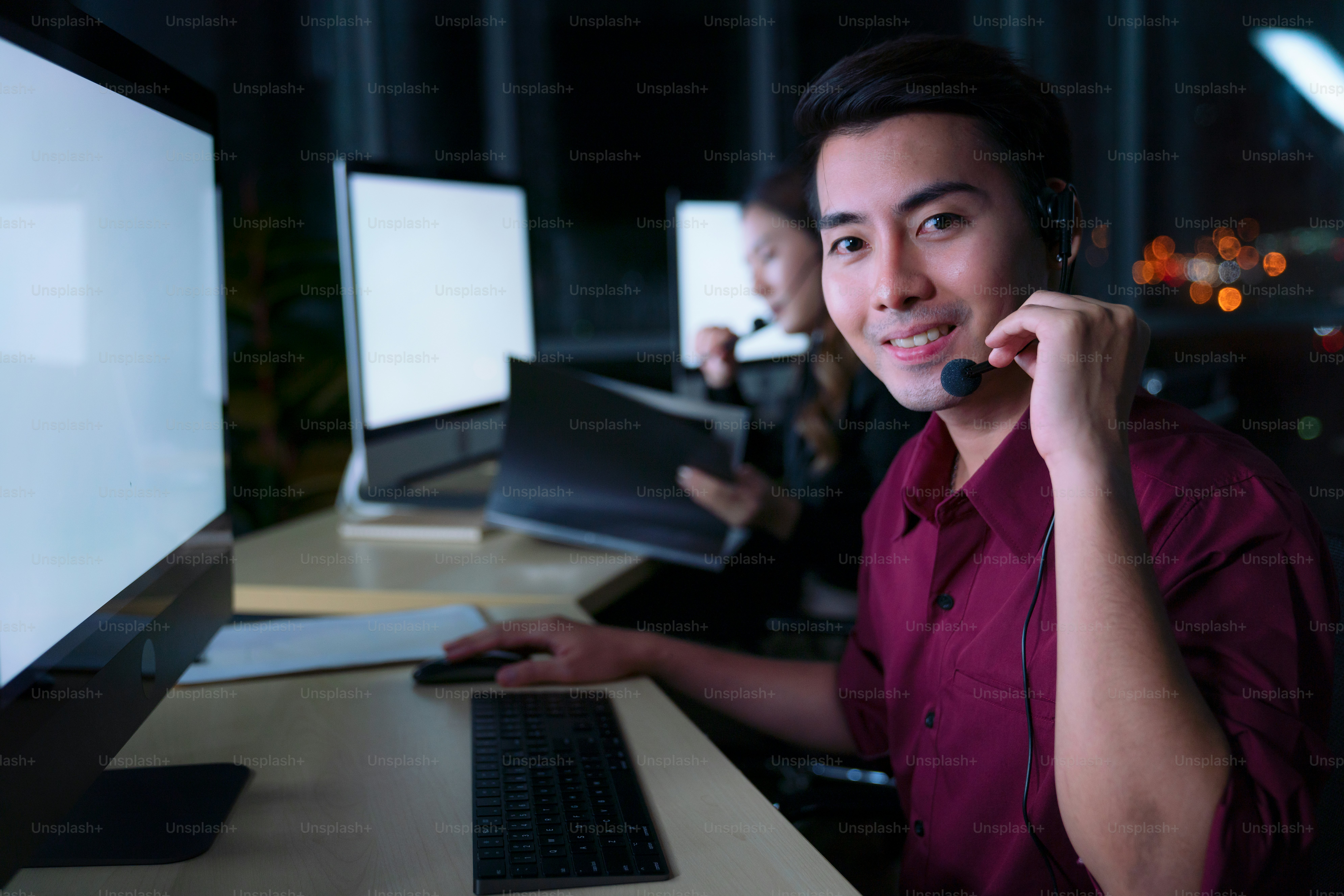 Thai Asian man customer services care operators working night shift in call center for helping assistance client in workplace at night time, Friendly help desk operator working at night
