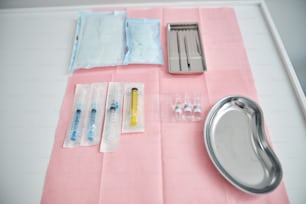 Vista dall'alto di diversi strumenti medici disposti su un tavolo per l'esecuzione di una procedura chirurgica