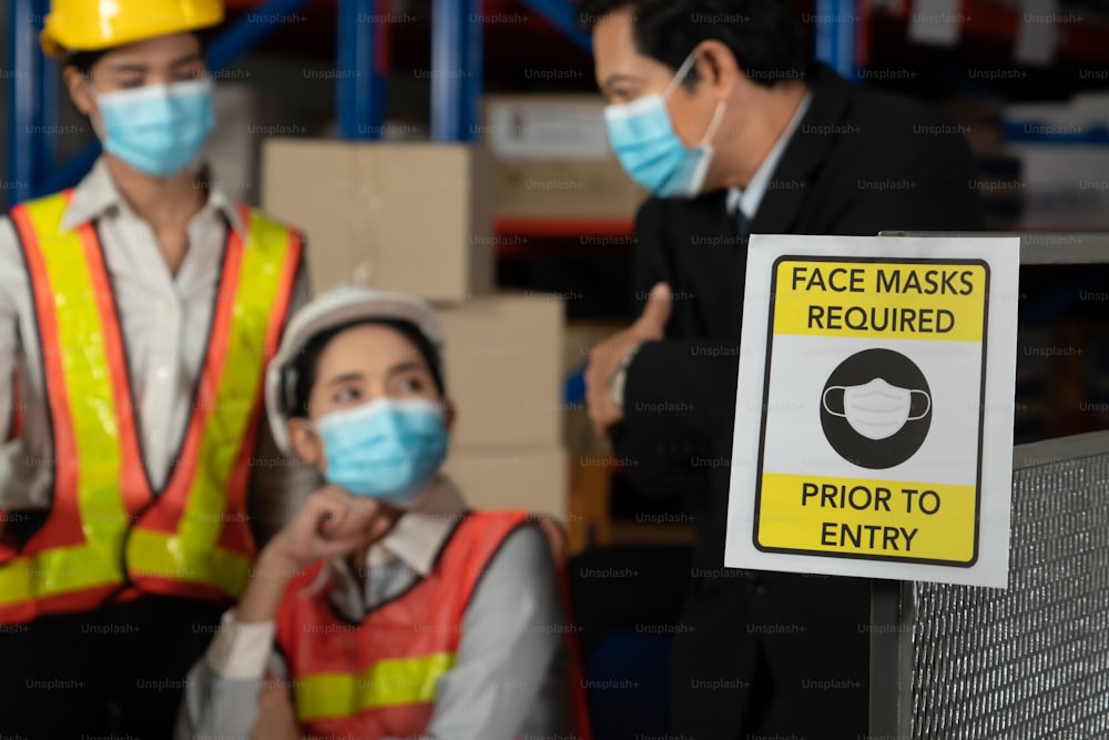 전염병 위기 이후 일자리 재개 기간 동안 Covid-19 코로나 바이러스가 확산되는 것을 방지하기 위해 산업 노동 노동자에게 경고하는 공장의주의 표시. 안전하게 일하는 개념.