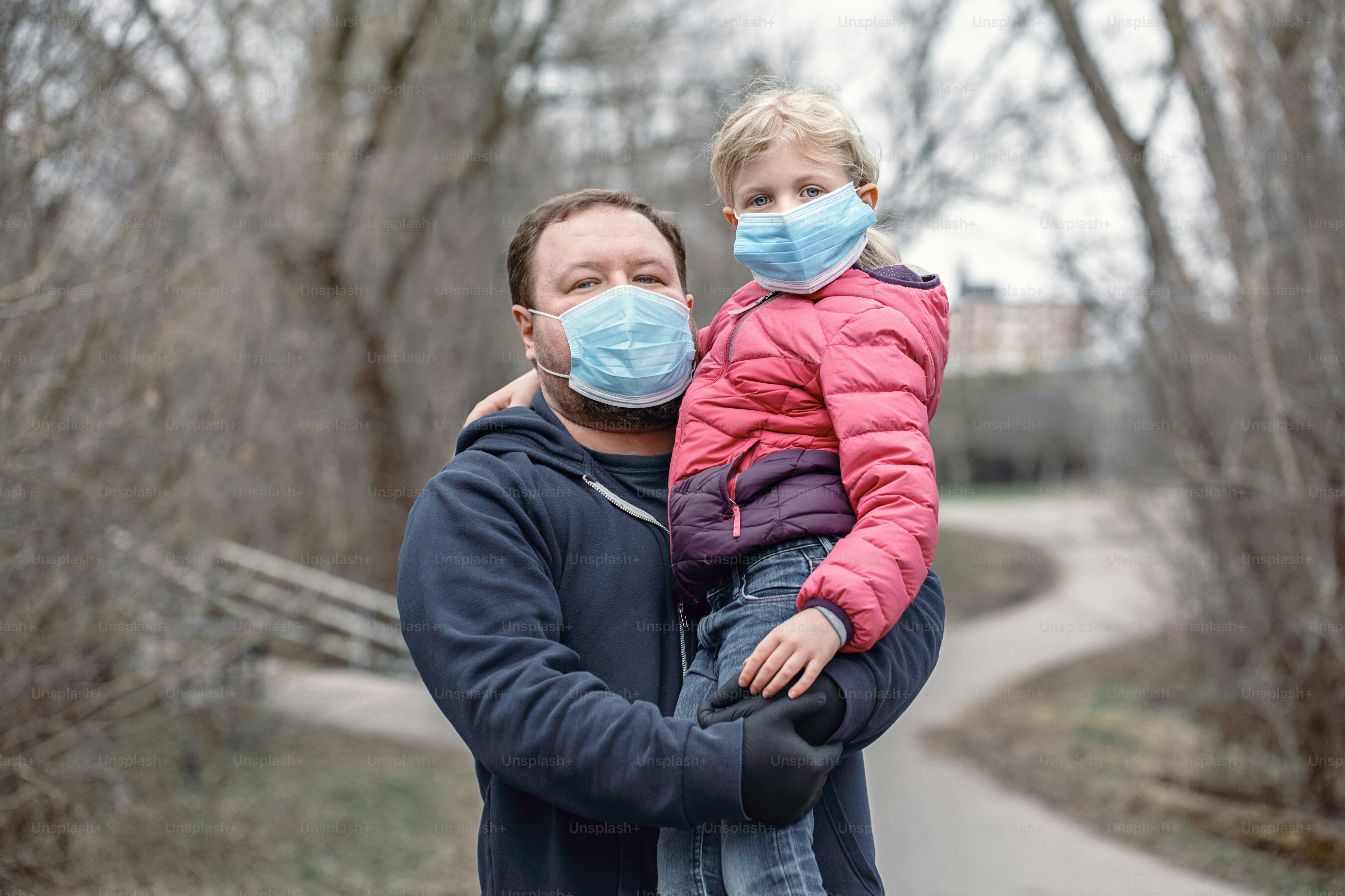 Caucasian father with child girl wearing sanitary face masks outdoor. Family dad and daughter protect themselves from dangerous spread of virus. Coronavirus COVID-19 quarantine.