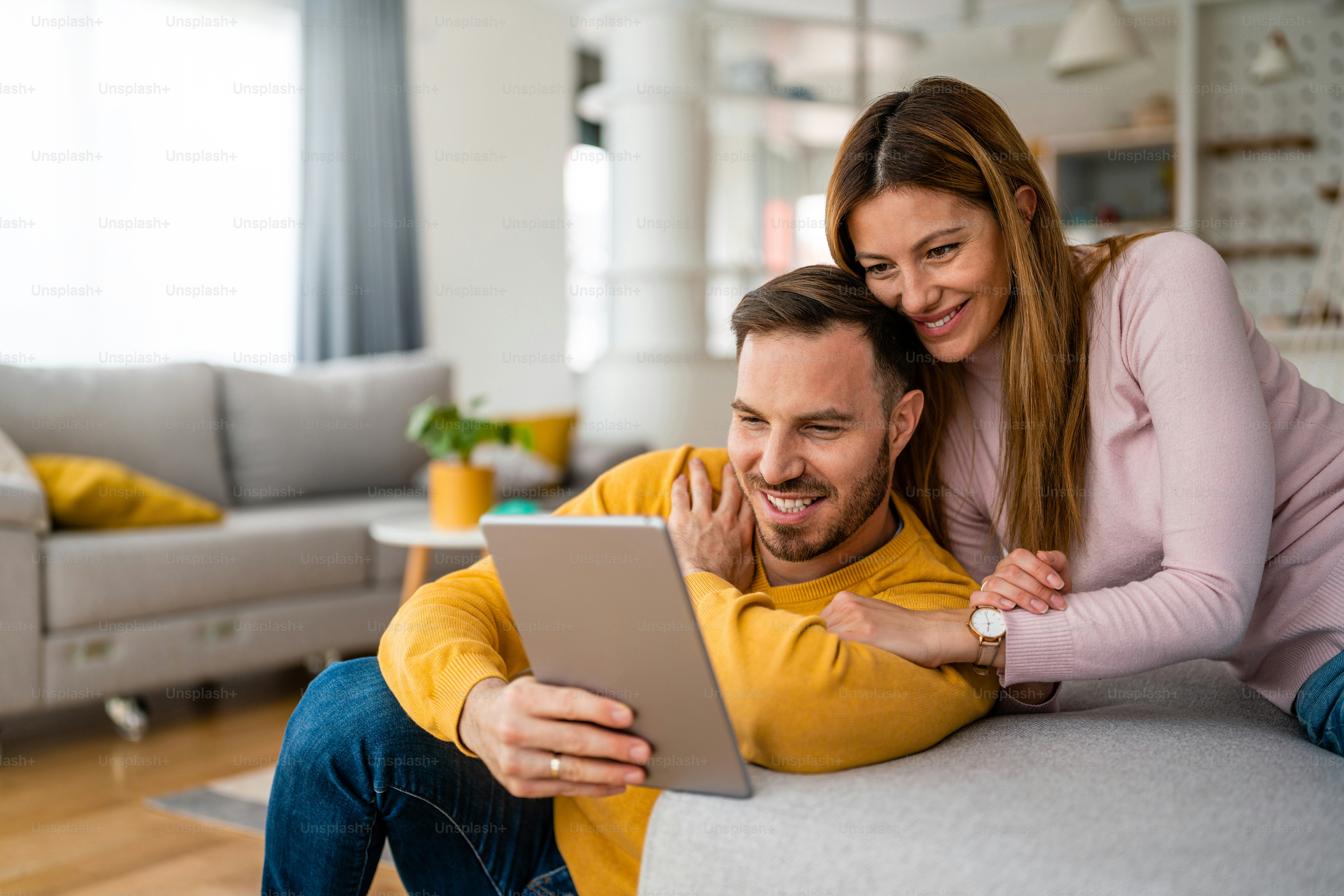 Couple in love using a tablet computer in their living room