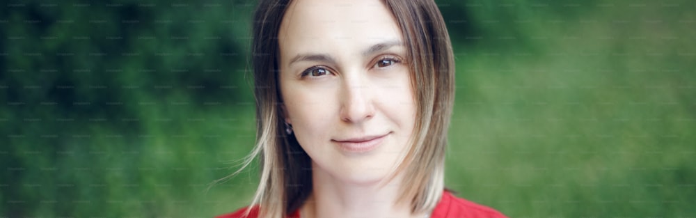 Portrait head shot of beautiful pensive Caucasian middle age woman with long light bob hair. Closeup face of happy calm real woman in park outside nature. Web banner header for website.