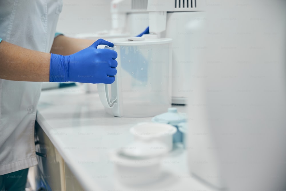 Close up portrait of work desk of dental clinic while doctor assistant cleaning and washing equipment