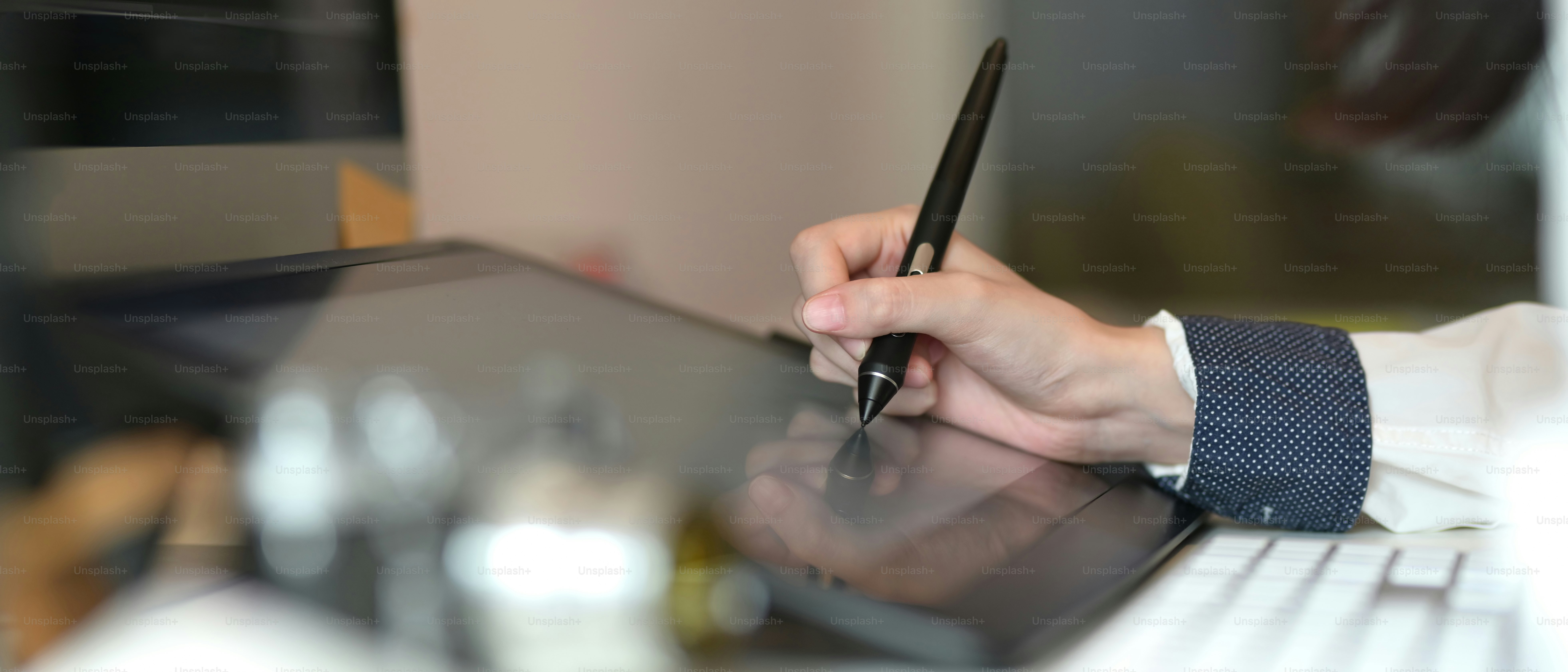 Bidikan yang dipotong dari desainer grafis wanita yang bekerja di tablet grafis di ruangan yang nyaman