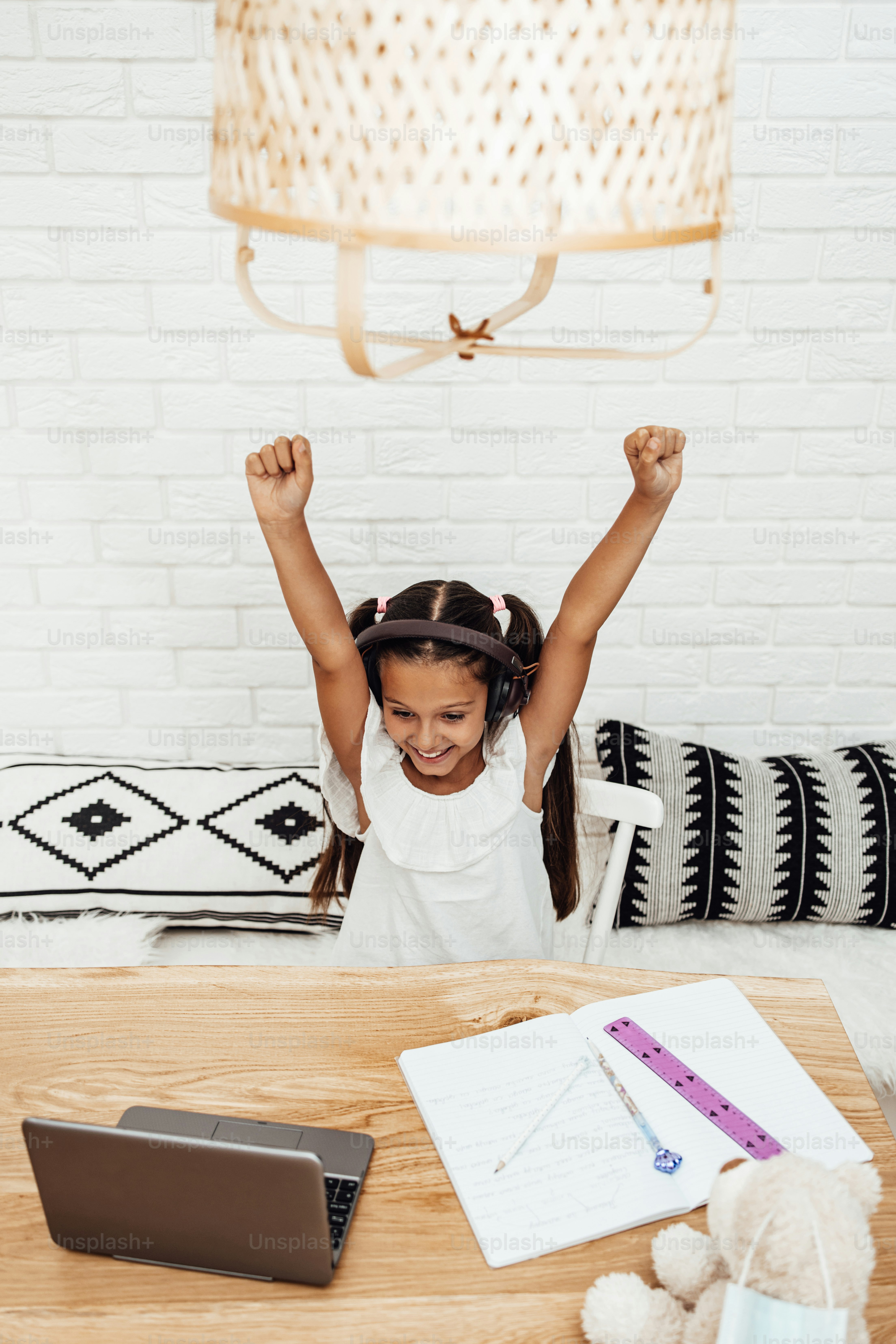 Young little girl having e-learning session during Covid-19 pandemic crisis lockdown or quarantine. Illness prevention and new normal concept.