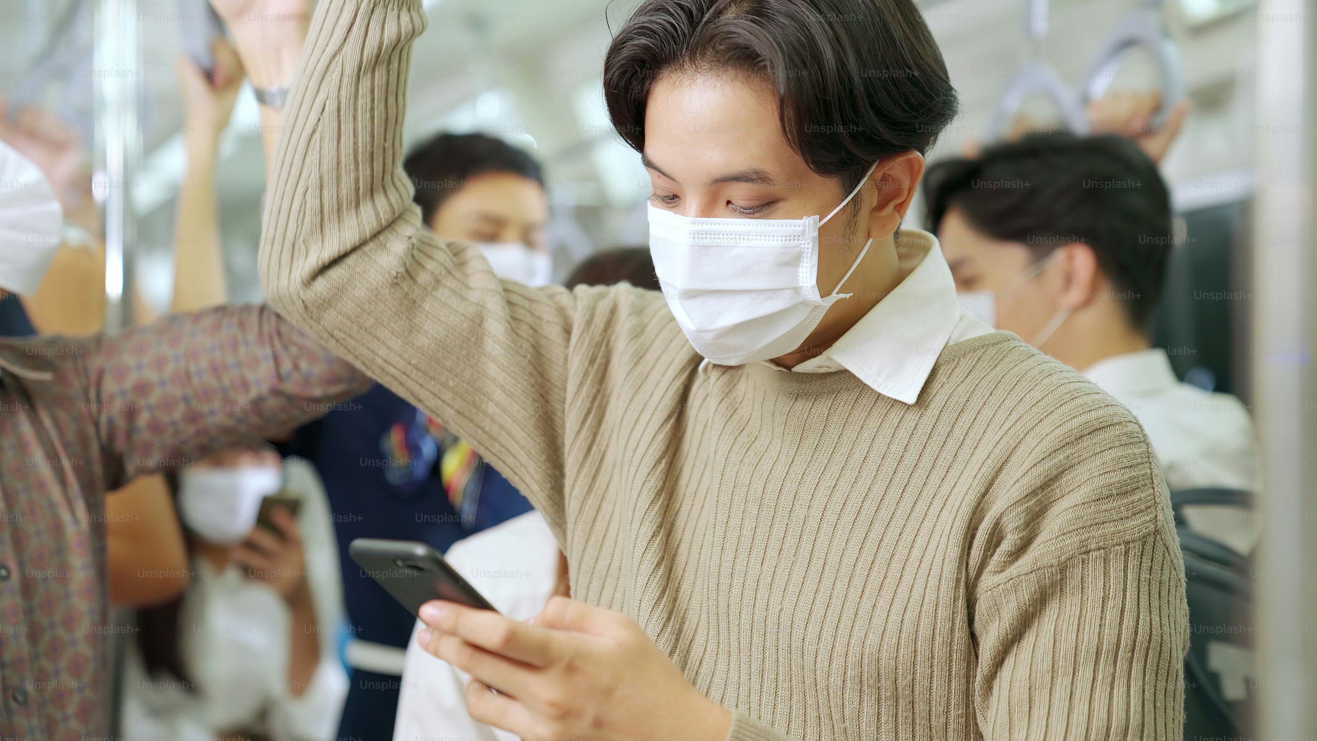 Traveler wearing face mask while using mobile phone on public train ...