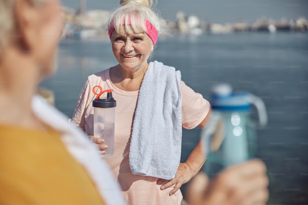 Front view of a pleased lady communicating with a male pensioner after the outdoor training