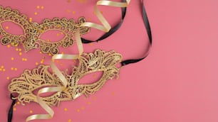 Maskiere goldene Masken und Konfetti auf rosa Hintergrund. Modell der Party-Einladungskarte
