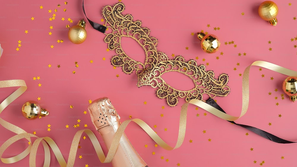 Fondo de fiesta de Navidad con serpentinas, botella de champán, decoraciones de bolas doradas, máscara de máscara. Plano, vista superior.