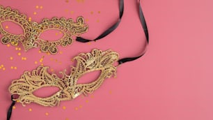 Máscaras douradas de carnaval e confetes no fundo rosa pastel. Flat lay, vista superior. Natal, conceito de máscara