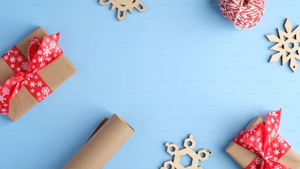 ギフトボックス、木製の雪片、包装紙と青いクリスマスの背景。クリスマス、冬休み、新年のコンセプト。フラットレイ、上面図、コピースペース。