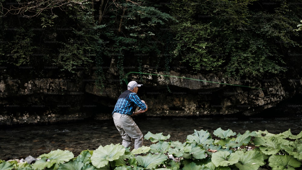 Senior man is fishing alone on fast mountain river. Active people and sport fly fishing concept.