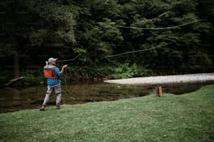 年配の男性は、速い山の川で一人で釣りをしています。アクティブな人々とスポーツフライフィッシングのコンセプト。