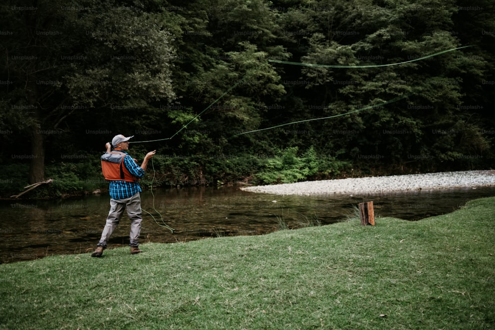 Der ältere Mann fischt alleine auf einem schnellen Gebirgsfluss. Aktive Menschen und Sport-Fliegenfischer-Konzept.