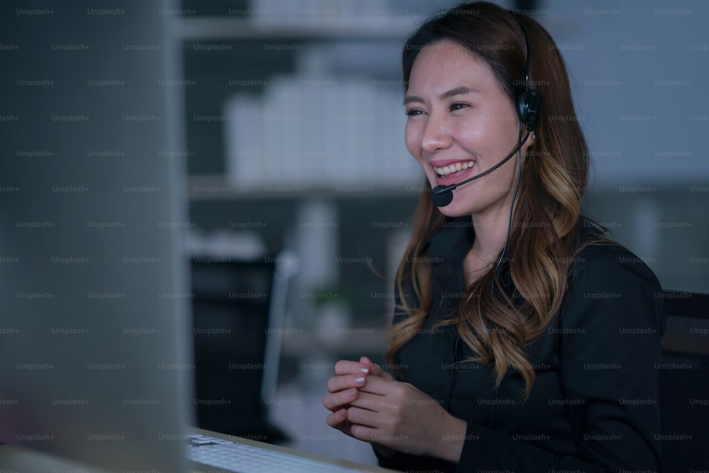 Thai portrait of business person wearing headset working, Young friendly operator woman agent in a call centre.