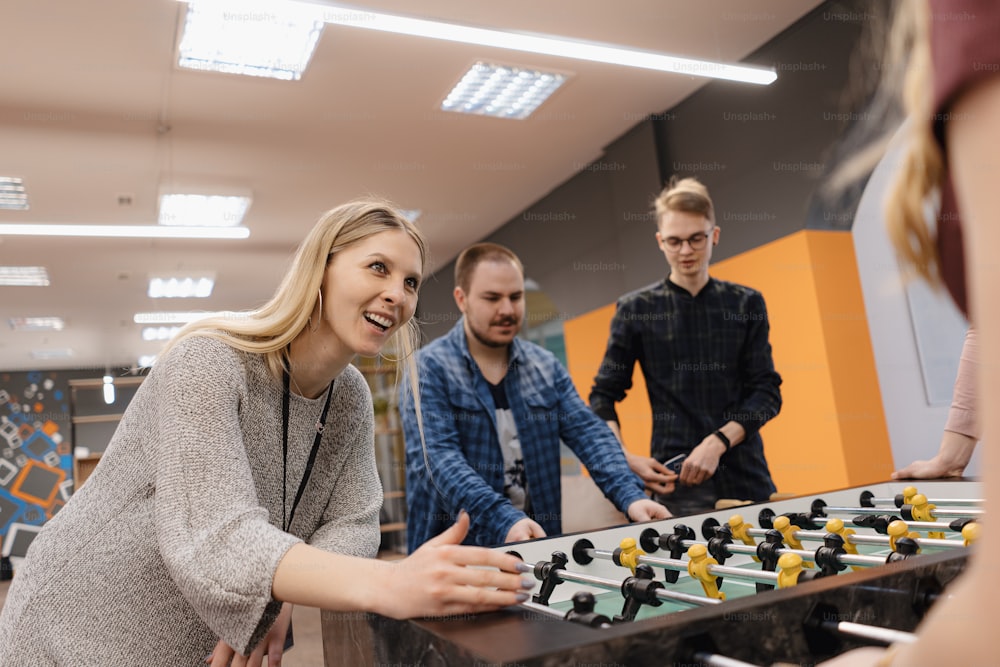 Group of Young Office Workers Playing Table Soccer Game Inside the Office During their Break time.