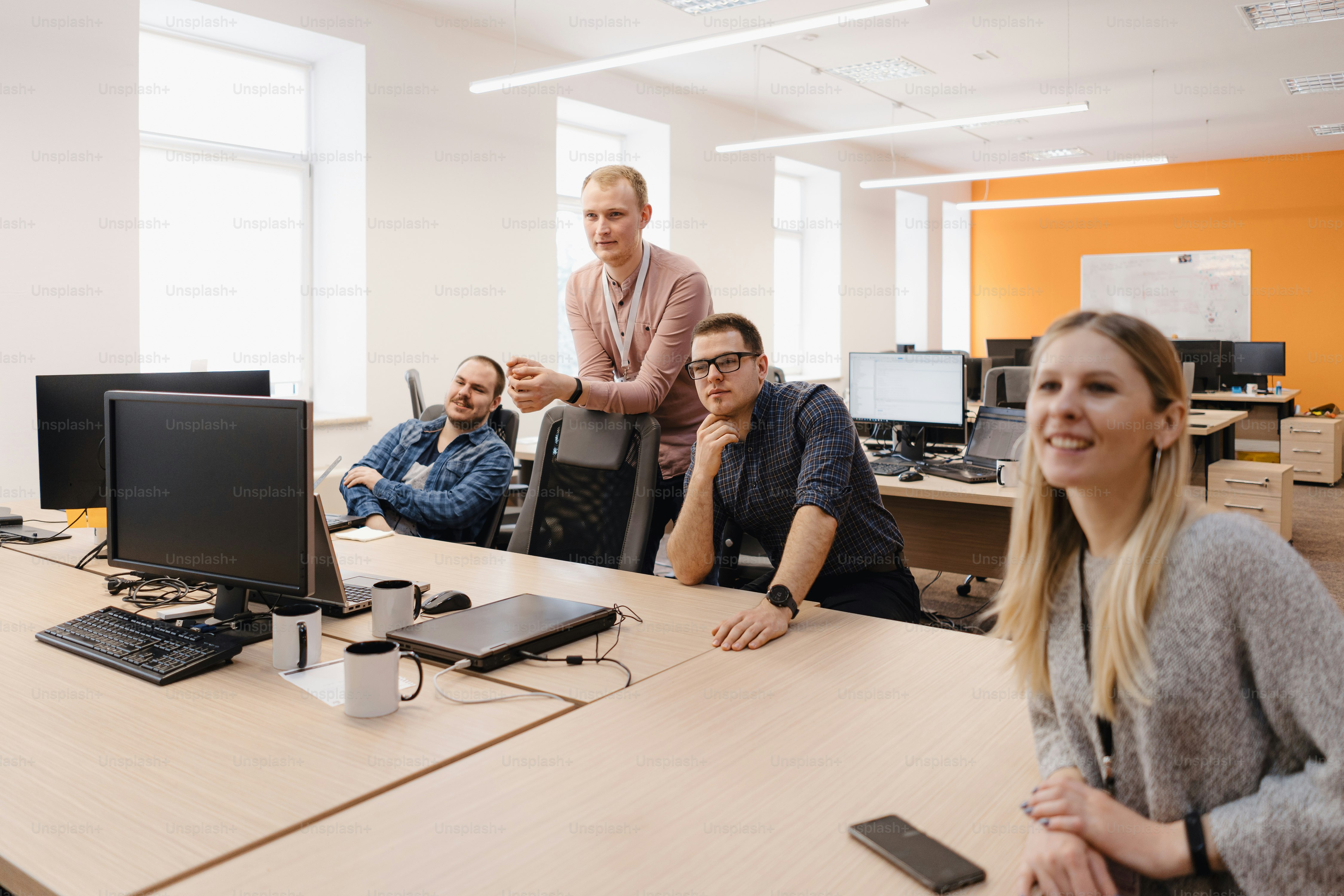 Full concentration at work. Group of young business people working and communicating while sitting at the office desk together with colleagues