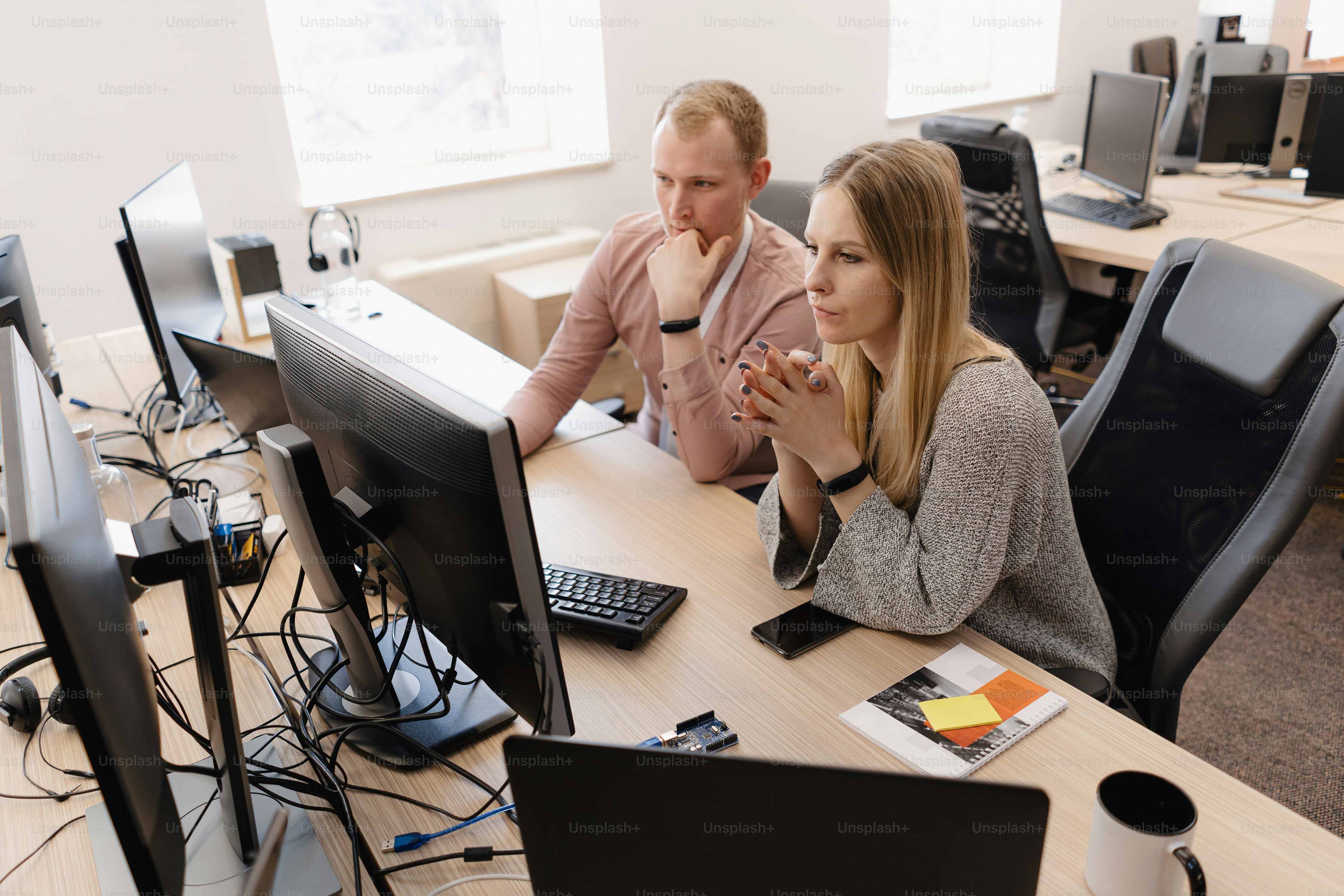 Full concentration at work. Group of young business people working and communicating while sitting at the office desk together with colleagues