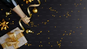 Premium luxury Christmas background with champagne bottle, gift box, party streamers, golden confetti stars on black. Flat lay, top view, copy space. Christmas party banner mockup.