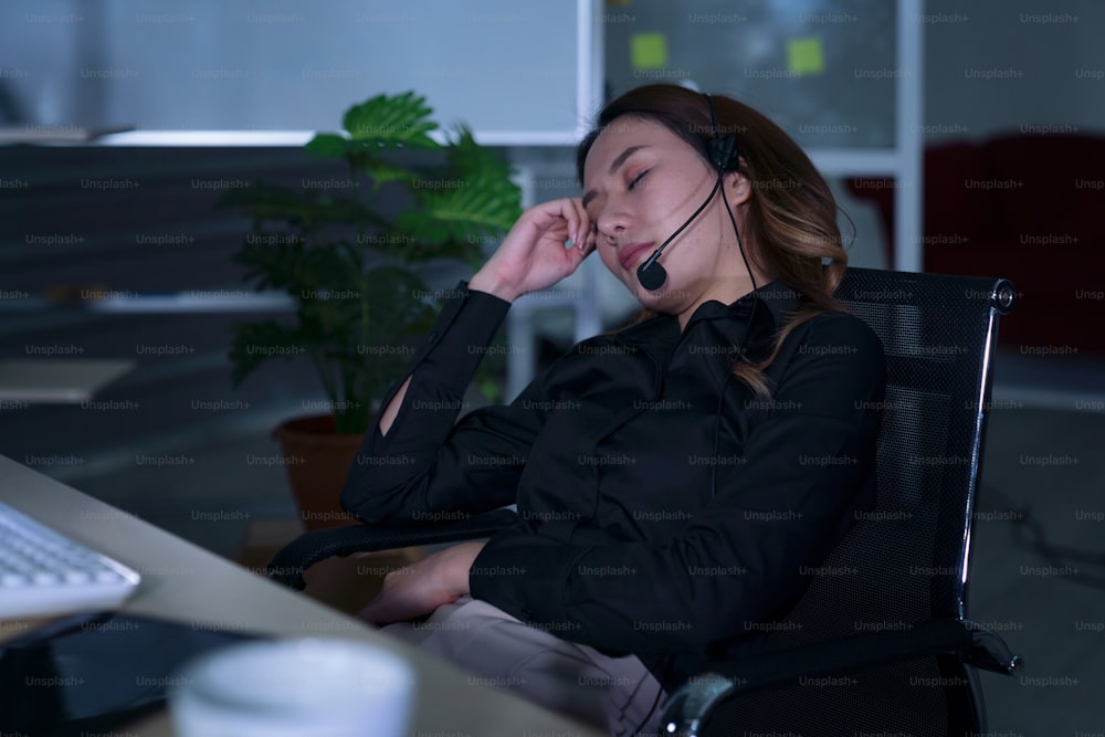 Thai asian women call center business people get headache and migraine from working late night shift for helping assistance customer in workplace at night time