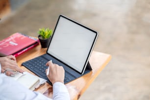 Maquette. Image d’une femme travaillant avec une tablette avec un écran blanc vide au bureau.