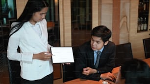 Femme d’affaires utilisant une tablette pour la présentation lors d’une réunion d’affaires au bureau.