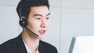 Business people wearing headset working in office to support remote customer or colleague. Call center, telemarketing, customer support agent provide service on telephone video conference call.