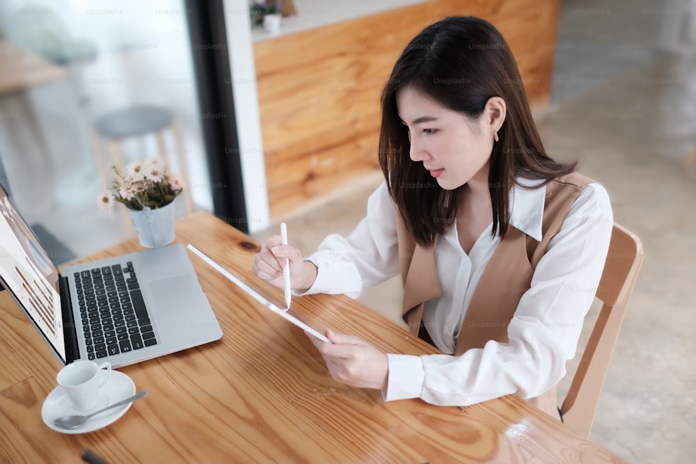 Smiling female working with tablet computer, above shot photo.