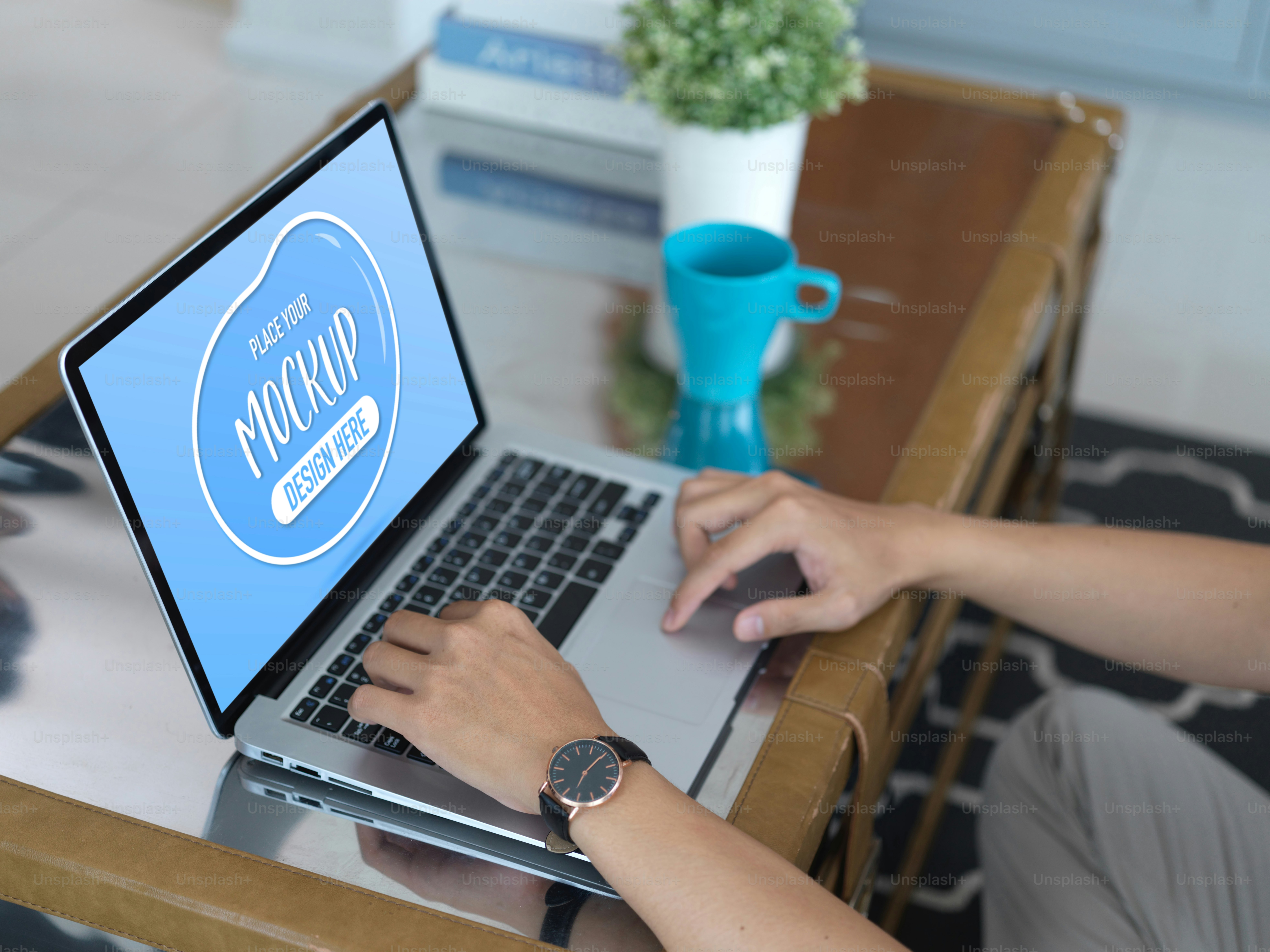 Cropped shot of male hands using mock up laptop on coffee table in living room