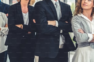 Successful business people standing together showing strong relationship of worker community. A team of businessman and businesswoman expressing a strong group teamwork at the modern office.