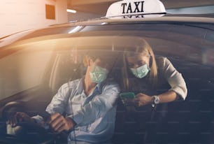 New normal. Teenager sitting in the back of a car with a mask. Young woman in a taxi protected by a mask. Road safety. Coronavirus pandemic. use smartphone find route travel