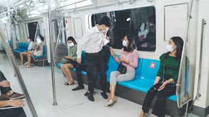 여자는 사회적 거리두기를 위해 기차에서 남자가 그녀 옆에 앉는 것을 막습니다. 코로나바이러스 질병 또는 COVID 19 팬데믹 발생 및 러시 아워 개념의 도시 생활 방식 문제.